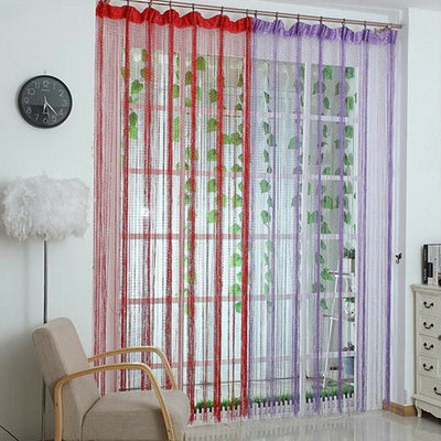 Hand holding a section of a silver shimmering string curtain with sparkling threads, ideal for door or room partition.