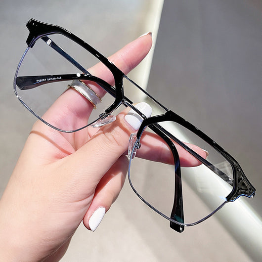 Anti-blue light glasses with a sand black and silver double beam frame, held against a white case.
