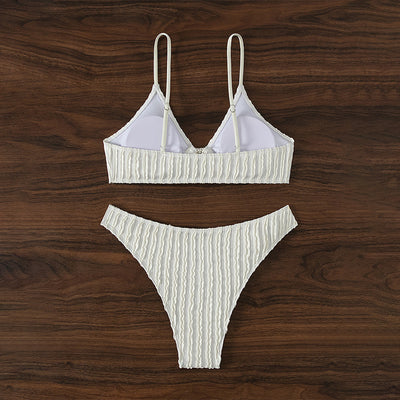 Women's white ribbed V-neck bikini with a front tie top and side ring bottoms, modeled by the ocean. - Image 4