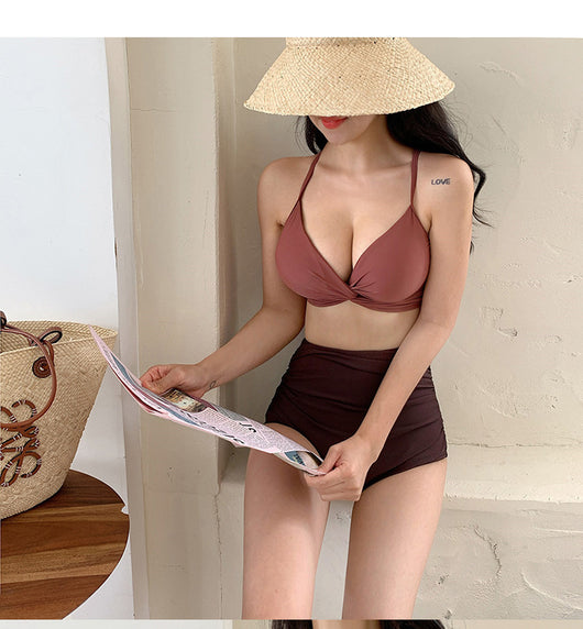 Woman in a blue twisted triangle bikini top and white high-waisted bottoms, holding a leaf-print cover-up. - Image 17