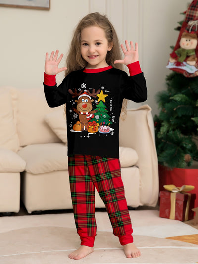 Two children in black and red plaid Christmas pajamas with a reindeer and Christmas tree graphic, standing by a Christmas tree. - Image 9