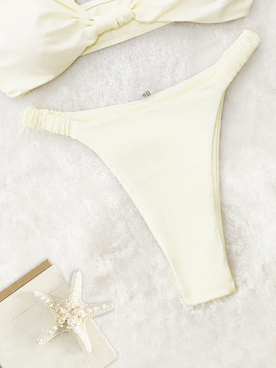 Woman wearing a royal blue two-piece bikini with a knotted front top and high-cut ruched bottom on a sandy beach. - Image 20