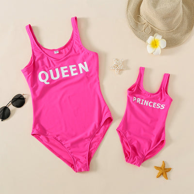 Rose pink one-piece swimsuit with 'QUEEN' printed in white on the front, featuring a scoop neck and tank straps. - Image 4