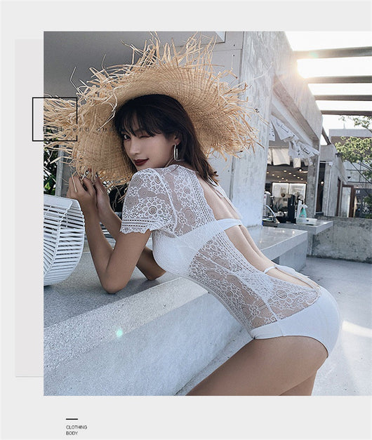 White lace cut-out one-piece swimsuit with short sleeves and a deep V-neckline, modeled by a woman. - Image 4