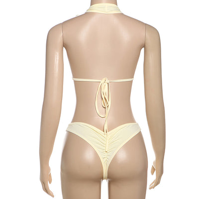 White halter monokini with deep V-neck, side cut-outs, and pearl bead embellishments on a woman at the beach. - Image 49