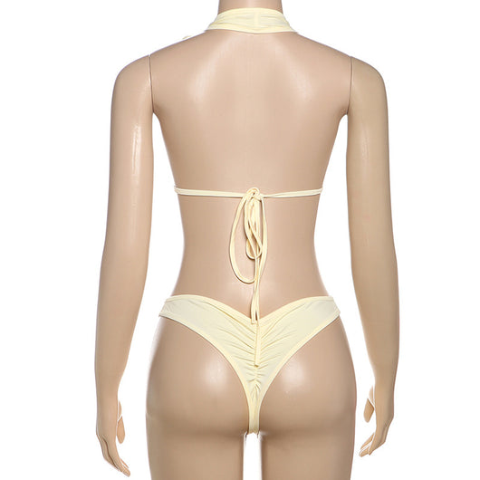 White halter monokini with deep V-neck, side cut-outs, and pearl bead embellishments on a woman at the beach. - Image 49