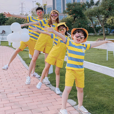 Family of four wearing matching yellow and blue striped t-shirts with daisy appliques. Mother and daughter wear yellow short overalls, father and son wear yello - Image 11