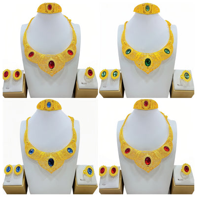 Golden jewelry set with a wide necklace, cuff bracelet, stud earrings, and ring, all featuring blue oval gemstones and intricate filigree patterns.