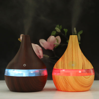 Dark wood grain USB mini tip air purifier and humidifier with a teardrop shape and a silver band.