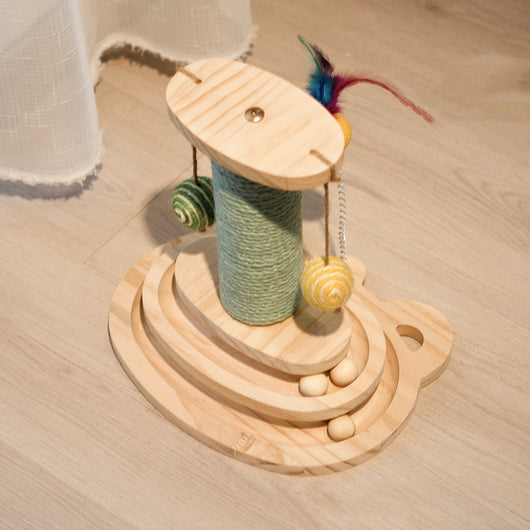 White cat playing with a wooden multi-level track toy featuring a spring-mounted yellow feather ball and a green catnip ball. - Image 7