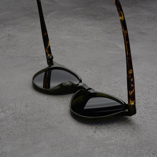 Fashionable round-frame sunglasses with transparent gray frames and dark gray lenses on a gray surface. - Image 14