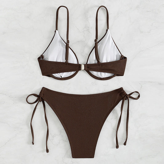 Black ribbed two-piece bikini with an underwire top and tie-side bottoms on a white marble surface. - Image 2