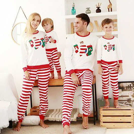 Father and son wearing matching Christmas pajamas with white long-sleeved tops featuring stocking prints and red and white striped pants. - Image 2