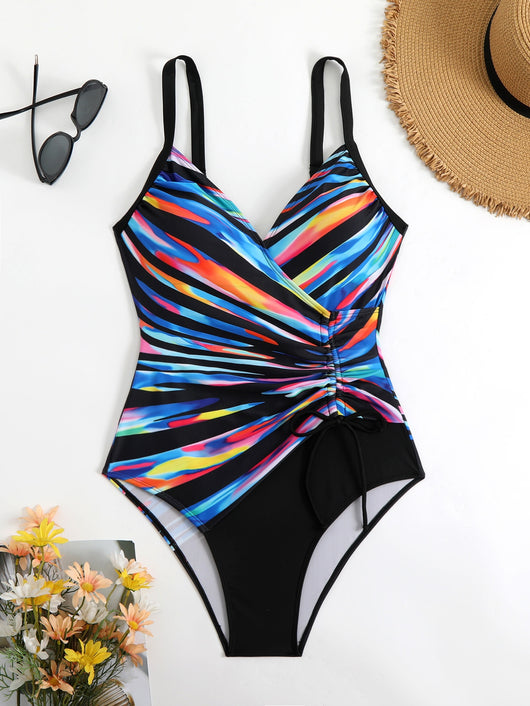 Woman in a navy and white striped tankini swimsuit with a wrap-front and side drawstring, holding a woven bag. - Image 21