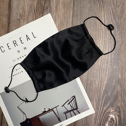 Light pink double layer silk face mask with adjustable white ear loops on an open magazine. - Image 6