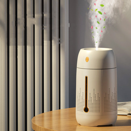 White cylindrical household humidifier with a visible water level indicator, next to its brown cardboard packaging. - Image 2