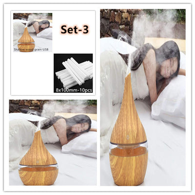 Dark wood grain LED essential oil diffuser with a blue light band and touch switch, shown with a hand operating it. Includes a bundle of 10 white filter sticks. - Image 12