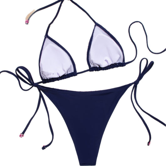 Navy blue bikini swimsuit set with pink floral lace trim on triangle top and tie-side bottoms, on a white knit blanket. - Image 5