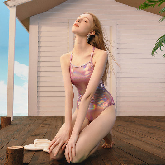 Woman wearing a shiny pink iridescent one-piece swimsuit with thin straps, ideal for racing or surfing. - Image 5