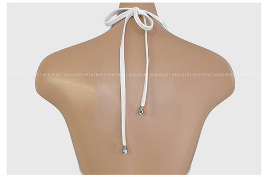 White and black striped bikini with triangle-cut top and tie-side bottom, modeled outdoors. - Image 11