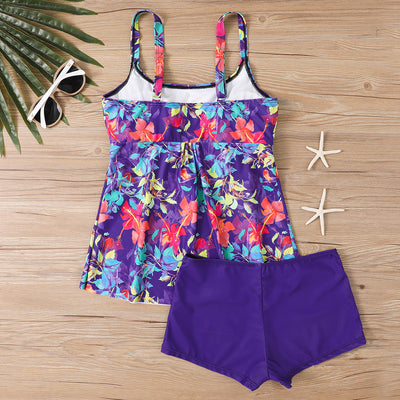 Woman in a black and white abstract print tankini top with black swim shorts on a sunny beach. - Image 15