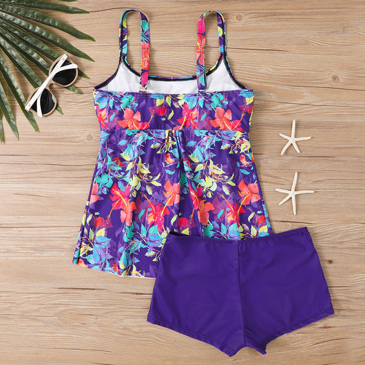 Woman in a black and white abstract print tankini top with black swim shorts on a sunny beach. - Image 15