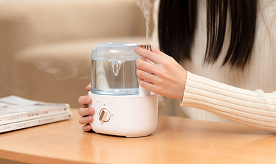 White and clear humidifier with a visible water vortex, emitting mist, and featuring a rose gold accent. - Image 15