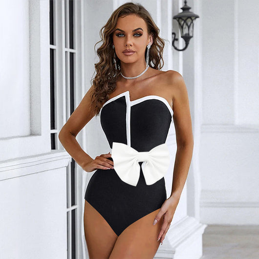 Black and white color-block one-piece swimsuit with an irregular tube top and a large white bow, paired with a matching pencil skirt. - Image 2