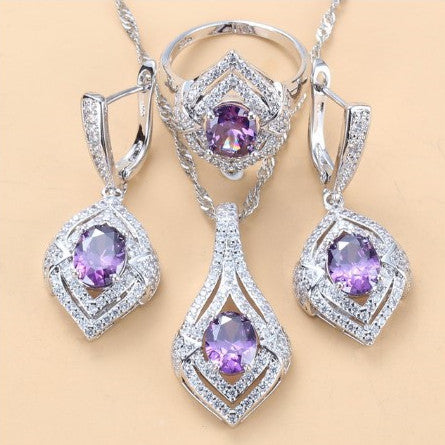 Silver-toned three-piece jewelry set with clear oval and round gems, including a necklace, dangle earrings, and a ring. - Image 11