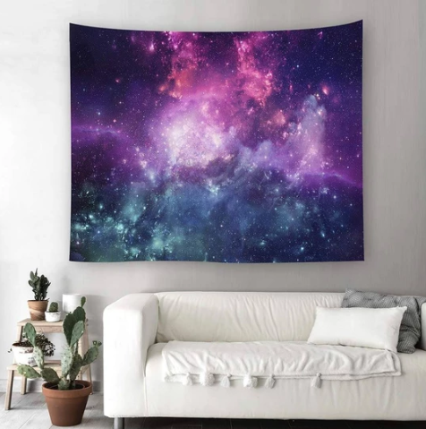 Blue Cosmos Tapestry with vibrant purple and blue galaxy print, hanging on a light gray wall above a white sofa.