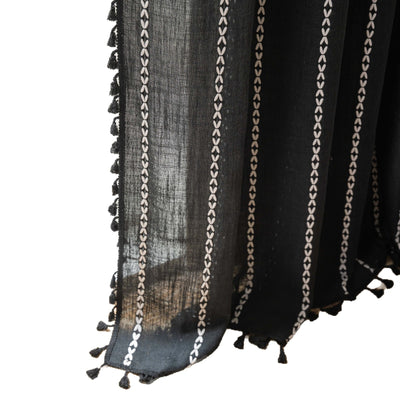 Black polyester curtain with white jacquard multi-line pattern and black tassels, draped over a white chair. - Image 5