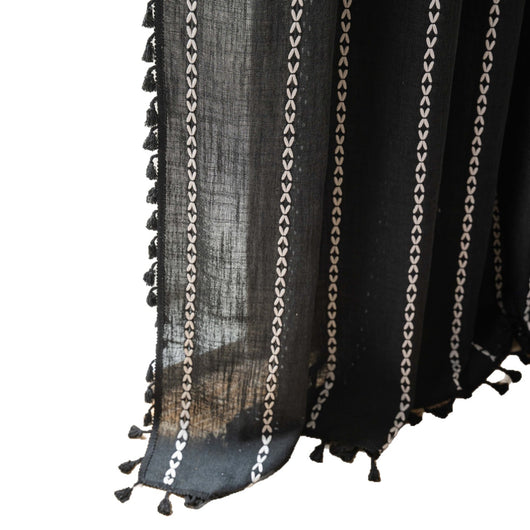 Black polyester curtain with white jacquard multi-line pattern and black tassels, draped over a white chair. - Image 5