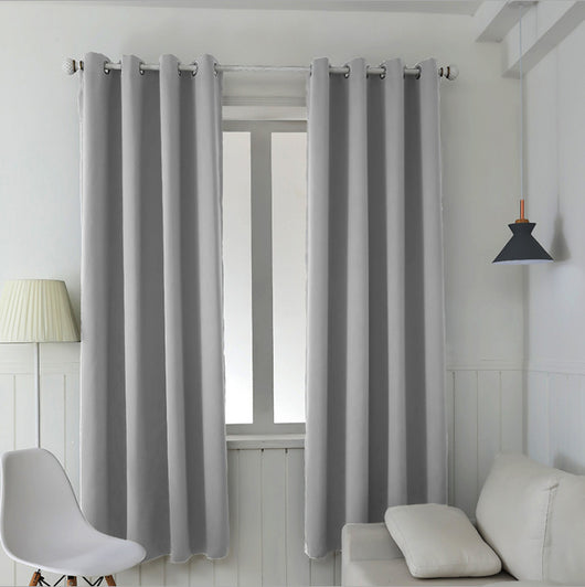 Light gray polyester blackout curtains with grommet tops hanging on a white rod in a modern living room. - Image 6