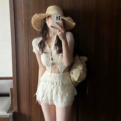 Fashion personalized black split bikini with sheer short-sleeve top, matching mini skirt with ruffle and lace trim.