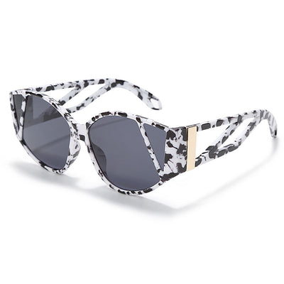 Light peach cat-eye sunglasses with purple gradient lenses and geometric cutouts on the frame.