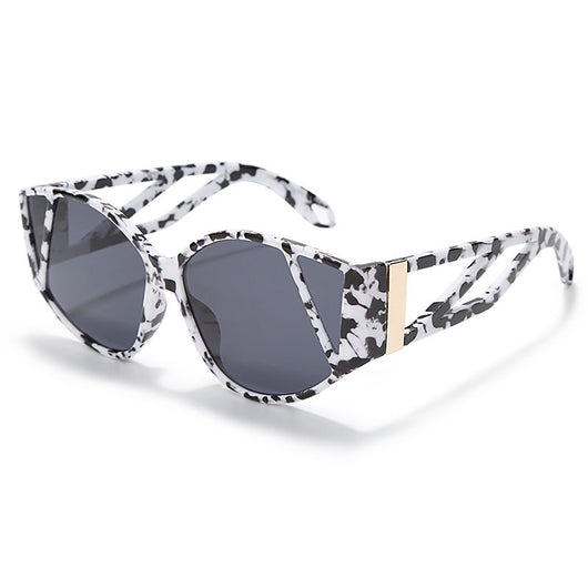 Light peach cat-eye sunglasses with purple gradient lenses and geometric cutouts on the frame.