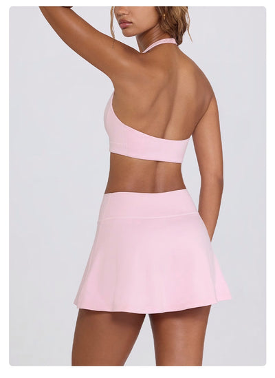 Light pink halter neck sports bra and high-waisted leggings workout set on a model. - Image 32