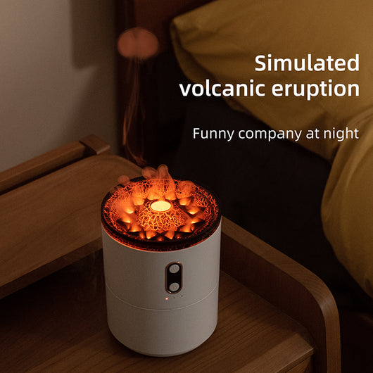 White volcanic flame aroma essential oil diffuser emitting orange light and mist on a wooden desk next to a laptop. - Image 5