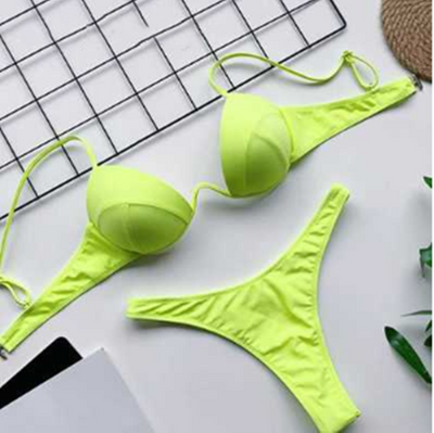 White two-piece bikini set with a push-up top and thong bottom, made of polyester, laid flat on a white surface. - Image 9