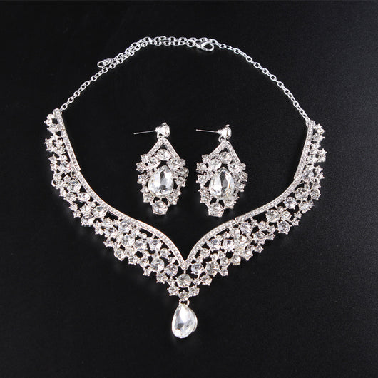 Sparkling silver-tone necklace and matching earrings set with clear round and teardrop rhinestones on a black display. - Image 5
