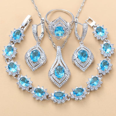 4-piece women's jewelry set with silver-tone necklace, ring, earrings, and bracelet, featuring red oval gemstones surrounded by clear accent stones. - Image 6