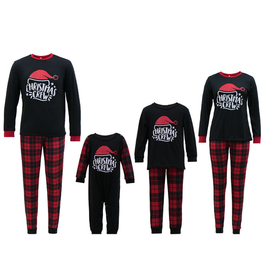Family of four wearing matching red and black plaid Christmas pajamas with "Christmas CREW" graphic, children in Santa hats. - Image 2