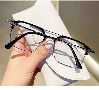 Anti-blue light glasses with a sand black and silver double beam frame, held against a white case. - Image 24