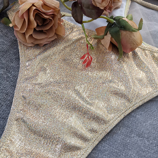 Woman wearing a shimmering gold one-piece swimsuit with a halter neck, crisscross straps, and stylish cut-out details. - Image 17
