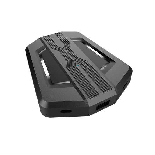 Black keyboard and mouse adapter for gaming consoles with yellow LED accents, next to its product box. - Image 2