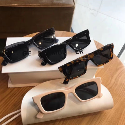 Transparent gray frame sunglasses with dark gray rectangular lenses and small gold accents on the temples. - Image 5