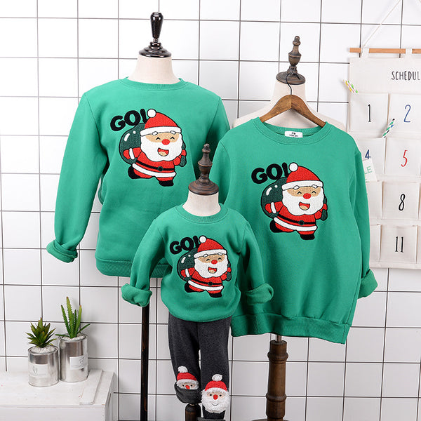 Red parent-child Christmas sweaters with a cartoon Santa Claus graphic, displayed on adult and child mannequins.