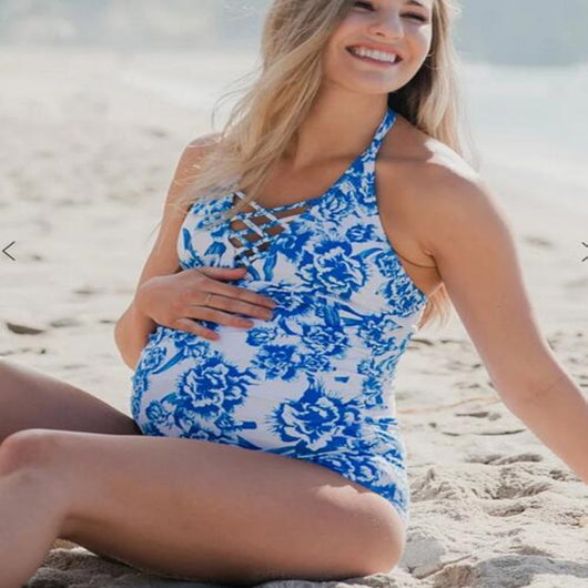 Women's blue and white floral print halter neck tankini top with ruched bottoms on a sandy beach. - Image 2