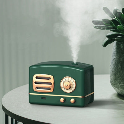 White retro humidifier with rose gold accents, designed like a vintage radio, emitting a fine mist.