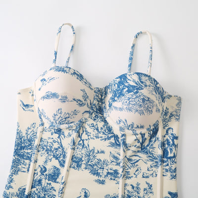 White sarong with blue toile de Jouy pattern featuring nature scenes, tied at the waist with a solid blue sash. - Image 2